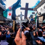 Christian Syrians lift crosses and independence-era flags as they rally in the Duweilaah area of Damascus