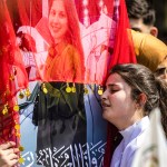 A woman reacts next to one of the pictures of victims of a recent wave of sectarian violence targeting Syria's Alawite minority.