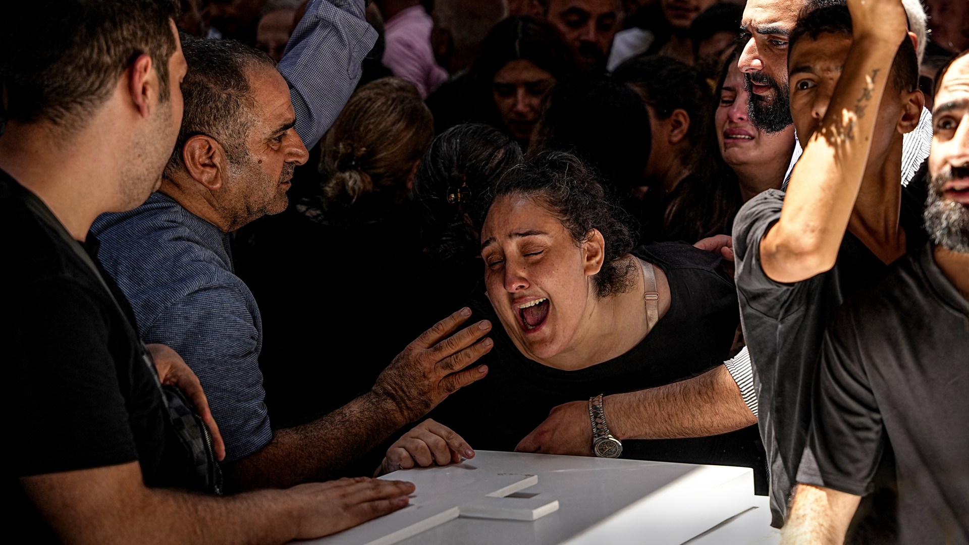 Relatives cry during the funeral of the people killed in the Saint Elias Greek Orthodox Church attack in Syria.